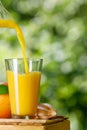 fresh orange juice pouring into glass outdoors Royalty Free Stock Photo