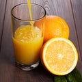 Fresh orange juice pouring into glass on the table Royalty Free Stock Photo