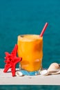 Fresh orange juice on the sea background. Royalty Free Stock Photo