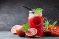 Fresh orange lemonade drink or juice decorated mint leaves in mason glass jar on black background.