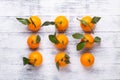 Fresh orange mandarins, tangerine with green leaves on white wooden background Royalty Free Stock Photo
