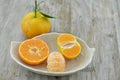 Fresh orange peeled and cut half n plate on wooden background Royalty Free Stock Photo