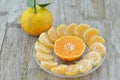 Fresh orange peeled and cut half in plate on wooden background Royalty Free Stock Photo