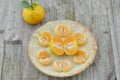 Fresh orange peeled and cut half in plate on wooden background Royalty Free Stock Photo