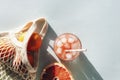 Fresh orange and red grapefruit juice with ingredients and mesh bag in sunlight. Top view, flat lay, copy space Royalty Free Stock Photo