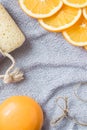 Background for bathing theme: the orange soap, the slices of orange and the bath sponge on the towel Royalty Free Stock Photo