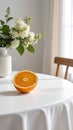 Fresh orange slice on white table with floral arrangement and natural light Royalty Free Stock Photo