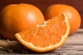 Fresh orange slice and whole orange on a wooden table