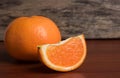 Fresh orange slice and whole orange on a wooden table