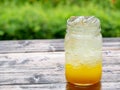 A fresh orange soda drink filled with ice in a vintage style glass container Full of ice in the glass.