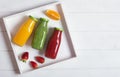 Fresh orange, strawberry and broccoli smoothie in bottles with fruits and mint in a white wooden rustic box and on a white backgro Royalty Free Stock Photo