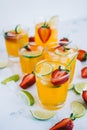 Fresh orange strawberry mojito in different glasses with ice cubes and slices of lime on the table. Summer refreshing drink Royalty Free Stock Photo