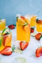 Fresh orange strawberry mojito in different glasses with ice cubes and slices of lime on the table. Summer refreshing drink Royalty Free Stock Photo