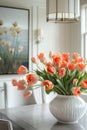 Fresh orange tulips in a white vase on a modern dining table Royalty Free Stock Photo