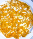 Fresh orange zest on a white plate. Raw citrus zest, grated orange peel, fresh zest on a white background Royalty Free Stock Photo