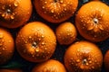 Fresh oranges on a dark background, some whole and some cut in half, covered in water droplets. Royalty Free Stock Photo