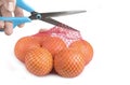 Fresh Oranges in a  Plastic Mesh Sack opened with scissors Royalty Free Stock Photo