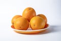 Fresh oranges on a plate isolated on a white background Royalty Free Stock Photo