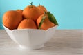 Fresh oranges in white porcelain Bowl. Healthy Citrus fruits on blue background. Kitchen Concept Royalty Free Stock Photo