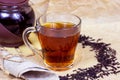 Fresh organic aromatic black tea in the glass cup on light background.