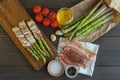 Fresh organic asparagus wrapped in Parma ham on a cutting board Royalty Free Stock Photo