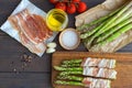 Fresh organic asparagus wrapped in Parma ham on a cutting board Royalty Free Stock Photo