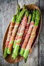 Fresh organic asparagus wrapped in Parma ham on a cutting board Royalty Free Stock Photo