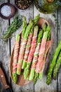 Fresh organic asparagus wrapped in prosciutto on a cutting board Royalty Free Stock Photo