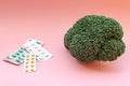 Fresh organic broccoli next to a cancer prevention pill. Proper nutrition or antibiotics, Healthy concept