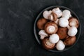 Fresh organic brown and white champignon mushrooms in bowl on dark stone background Royalty Free Stock Photo