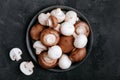 Fresh organic brown and white champignon mushrooms in bowl on dark stone background Royalty Free Stock Photo