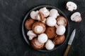 Fresh organic brown and white champignon mushrooms in bowl on dark stone background Royalty Free Stock Photo