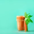 Fresh organic carrot juice with carrots, celery on blue background. Square crop. Vegetable smothie in glass. Banner Royalty Free Stock Photo