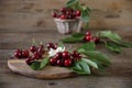 Fresh organic cherries in a wicker basket with leaves and white flowers on the wooden rustic background. Healthy food concept. Clo Royalty Free Stock Photo