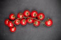 Fresh organic cherry tomatoes bunch closeup on black board background Royalty Free Stock Photo