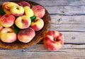 Fresh organic chinese flat peaches with leaves on a copper plate on old wooden rustic table.Saturn donut, Doughnut peach, Paraguay Royalty Free Stock Photo