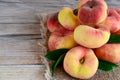 Fresh organic chinese flat peaches with leaves on old wooden background.Saturn donut, Doughnut peach, Paraguayo.Healthy eating or Royalty Free Stock Photo