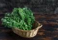 Fresh organic curly kale leaves in a basket on a brown wooden table and on a dark wooden background gmo free,  rustic style, copy Royalty Free Stock Photo