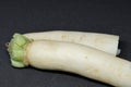 Fresh organic daikon radishes isolated on black background