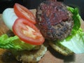 Filling of a large beef burger on a wooden board