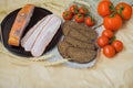 Fresh organic Food. Quick tasty snack. Close-up view of slices of pink bacon, pieces of rye bread, ripe red tomatoes Royalty Free Stock Photo