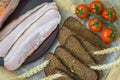 Fresh organic Food. Quick tasty snack. Close-up view of slices of pink bacon, pieces of rye bread, ripe red tomatoes Royalty Free Stock Photo