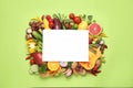 Fresh organic fruits, vegetables and blank card on green background, flat lay. Space for text Royalty Free Stock Photo