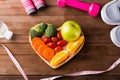 Fresh organic fruits and vegetables in heart plate wood and sports equipment