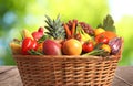 Fresh organic fruits and vegetables in wicker basket on wooden table, closeup Royalty Free Stock Photo