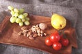 Fresh organic fruits and vegetables on wooden Serving tray. Assorted apple, pear, grapes, tomatoes and nuts. Royalty Free Stock Photo