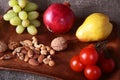 Fresh organic fruits and vegetables on wooden Serving tray. Assorted apple, pear, grapes, tomatoes and nuts. Royalty Free Stock Photo