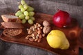 Fresh organic fruits on wood Serving tray. Assorted apple, pear, grapes, dried fruits and nuts.