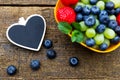 Fresh organic fruits on wooden table, black heart Royalty Free Stock Photo