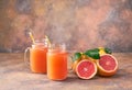Jar of fresh grapefruit juice and cut fruits on a abstract bac Royalty Free Stock Photo